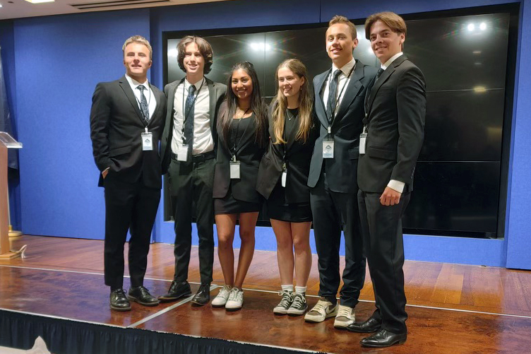 Empowering Future Leaders: DTG-C Proud Sponsor of San Juan Hills High School's NYC Nationals Journey 5 SJH VE team on stage